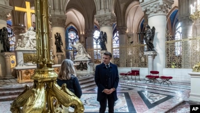 French President Emmanuel Macron speaks with an art restorer as he visits the restored interiors of the Notre-Dame de Paris cathedral, Nov. 29, 2024 in Paris.