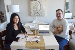 Karina L. Lopez, left, poses with her fiance Curtis Rogers and their dog Fifi at their home in the Long Island City section of the Queens borough of New York, April 4, 2020.