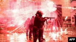 FILE - Fireworks shot by protesters explode near police in riot gear firing tear gas during a nationwide protests against the Georgian government's decision to shelve EU membership talks, in Tbilisi, Dec. 2, 2024.