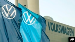 Flags wave in front of a factory building during the production restart of the plant of the German manufacturer Volkswagen AG (VW) in Zwickau, Germany, Thursday, April 23, 2020. 