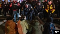 Policija hapsi propalestinske pristalice koji su blokirali cestu nakon što je policija očistila palestinski protestni kamp Emerson Collegea u Bostonu, Massachusetts, 25. aprila 2024.