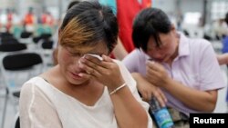 Family members cry at a caring centre for relatives of victims of a factory explosion, in Kunshan, Jiangsu province, August 3, 2014. 