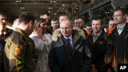 FILE - In this March 6, 2018, file photo, Russian President Vladimir Putin listens to employees of Uralvagonzavod factory in Nizhny Tagil, Russia.