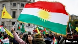 FILE - A woman waves a Kurdish flag during a pro-Kurdish rally against Turkey's military action in northeastern Syria, in London, Britain, Oct. 13, 2019. 