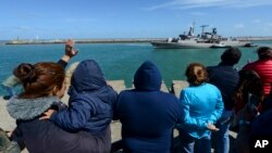 Warga dan keluarga awak kapal selam Argentina di pangkalan Mar del Plata melambai kepada awak kapal perusak "Sarandi" yang bergabung untuk melakukan pencarian kapal selam yang hilang (21/11). 