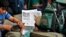 A newspaper shows news about people leaving the city at a railway station in Bangalore, India, Aug. 16, 2012.