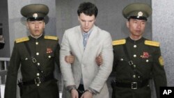 Otto Warmbier (tengah) dikawal oleh dua tentara Korea Utara di Mahkamah Agung di Pyongyang, tahun lalu (foto: dok). 