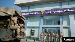 Lebanese army soldiers stand guard outside a branch of Byblos Bank in the southern city of Sidon among financial turmoil.