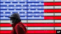 A pedestrians wearing a protective mask during the coronavirus pandemic walks along Seventh Avenue in Times Square, Saturday, May 23, 2020, in New York. (AP Photo/Frank Franklin II)