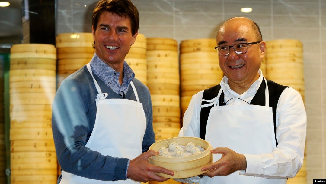 Aktor Tom Cruise berpose bersama Presiden Din Tai Fung Yang Chi-hua dan xiaolongbao, atau dumpling alias pangsit khas restoran tersebut (6/4).