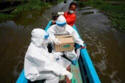 Public health officers travel by boat to bring coronavirus swab testing to residents living in remote communities, amid the rise of coronavirus disease infections, in Samut Prakan, near Bangkok, Thailand, July 19, 2021.
