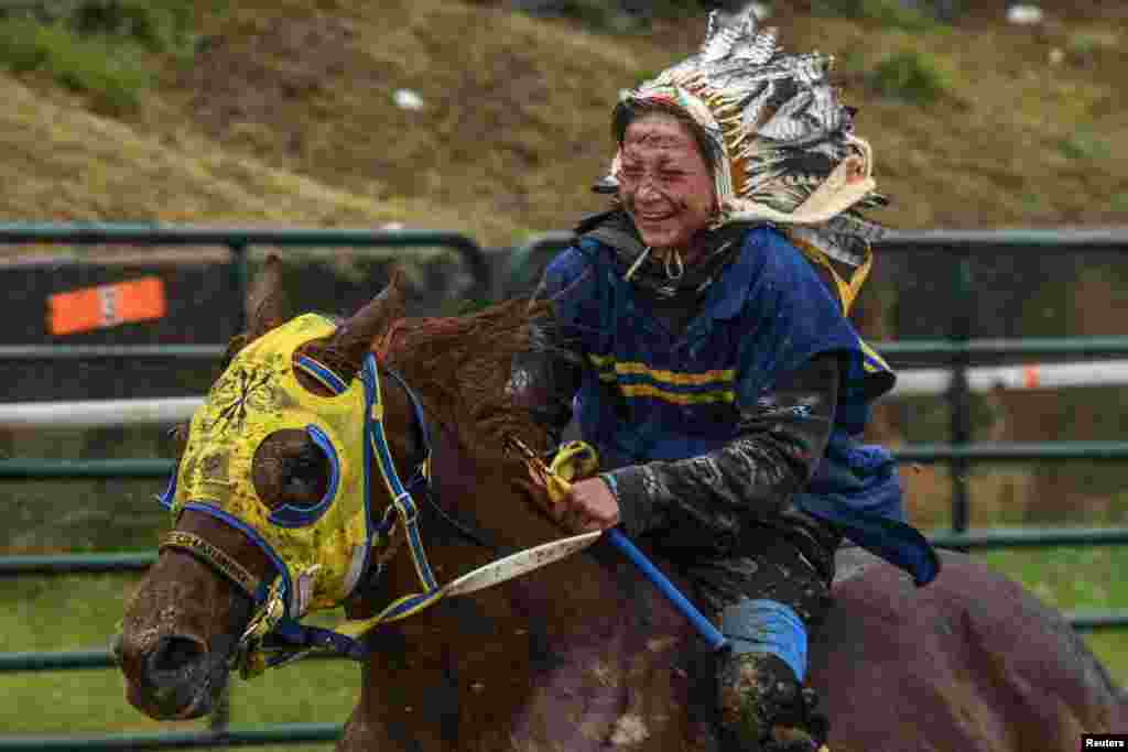 A rider is covered in mud as Native Americans participate in an Indian relay race over Memorial Day weekend at the Osage County Fairgrounds in Pawhuska, Oklahoma, May 31, 2021.