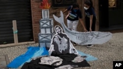 Activistas sostienen un recorte que representa un esqueleto de ballena en el Día Mundial de los Océanos, en Río de Janeiro, Brasil, EL 8 de junio de 2021.