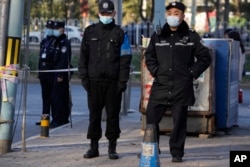 FILE - Chinese police officers are pictured near the Chaoyang district court in Beijing, Nov. 27, 2023.