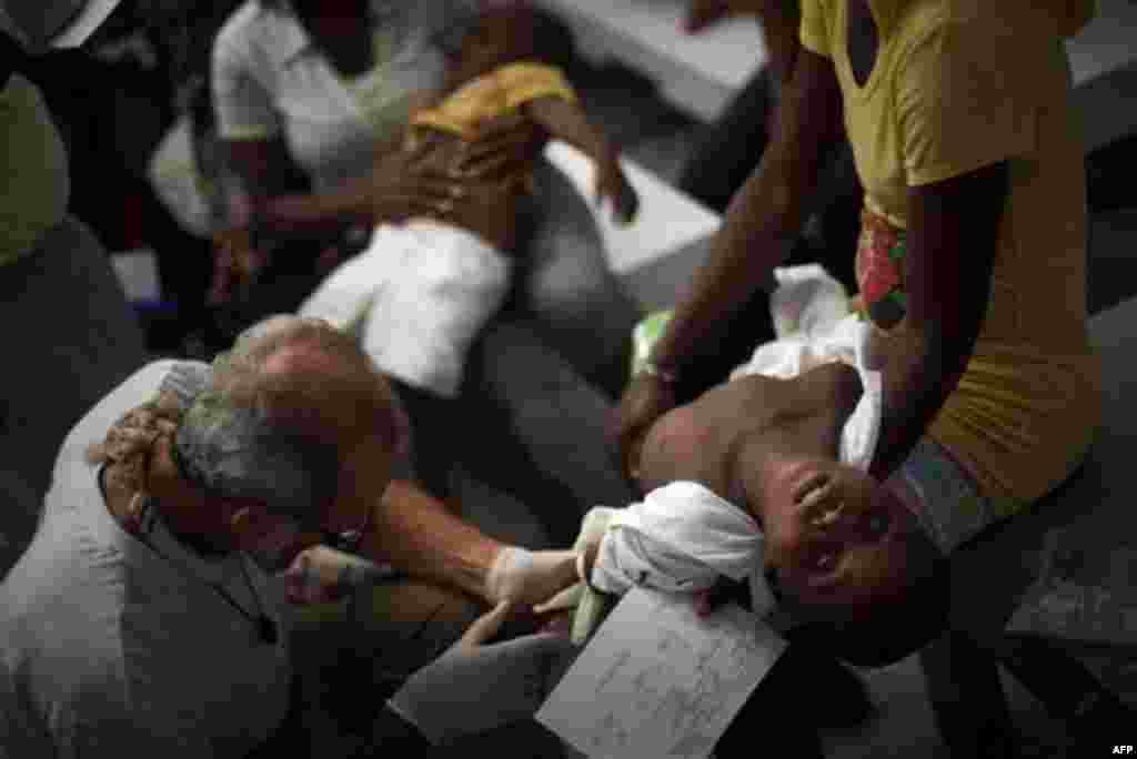 A child suffering cholera symptoms is checked by a doctor at the Doctors Without Borders temporary hospital in Port-au-Prince, Haiti, Tuesday Nov. 16, 2010. Thousands of people have been hospitalized for cholera across Haiti with symptoms including seriou