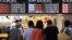 Passengers look at a noticeboard at Osaka station in Osaka, western Japan, as trains are delayed up to three hours due to rains from Typhoon Nangka, July 17, 2015.