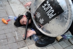 FILE - Police arrest a protester after a Chinese flag was removed from a flag pole at a rally in support of Xinjiang Uighurs' human rights in Hong Kong, China, Dec. 22, 2019.