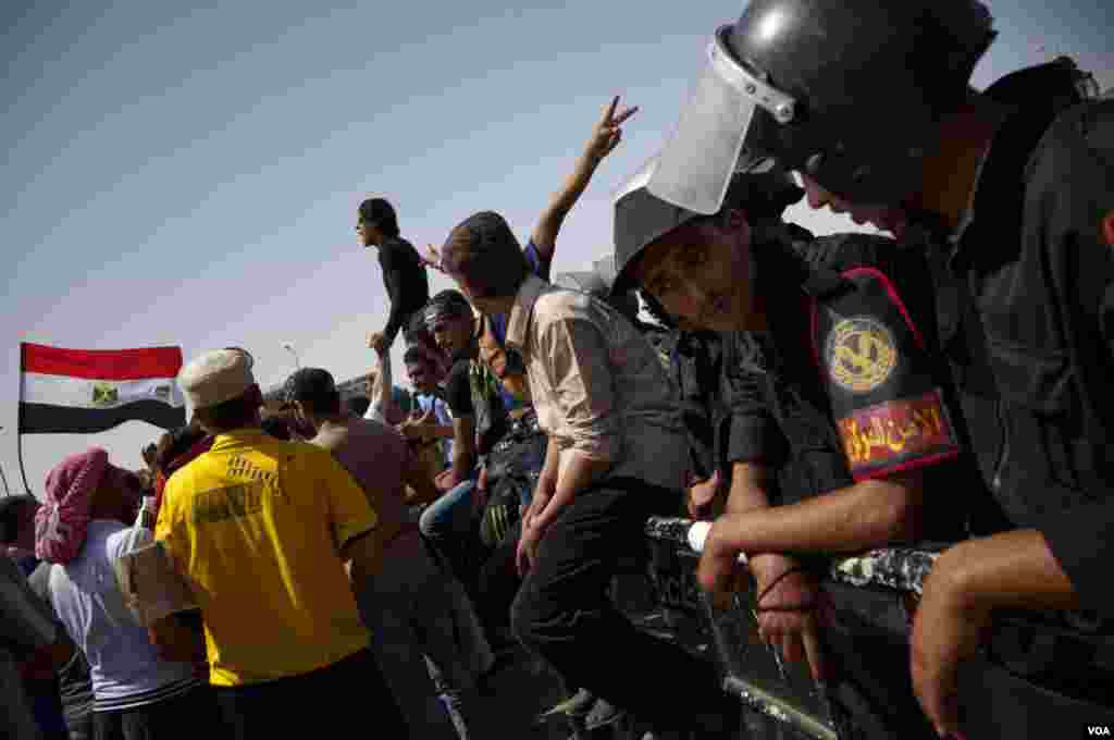 Riot police stand guard as anti-Mubarak protesters chant in the background in Cairo, June 2, 2012. (VOA/Y. Weeks)