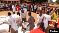 FILE - Displaced Kenyans stand in line for food and material relief at a school in Busia in eastern Uganda at the border of Kenya, Jan. 15, 2008. Fearing violence in connection with Tuesday's elections, this time again, some Kenyans have crossed the border.