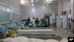 کارکنان آرامگاه بهشت زهرا در حال آماده کردن اجساد جان‌باختگان کرونا برای دفن - آرشیو