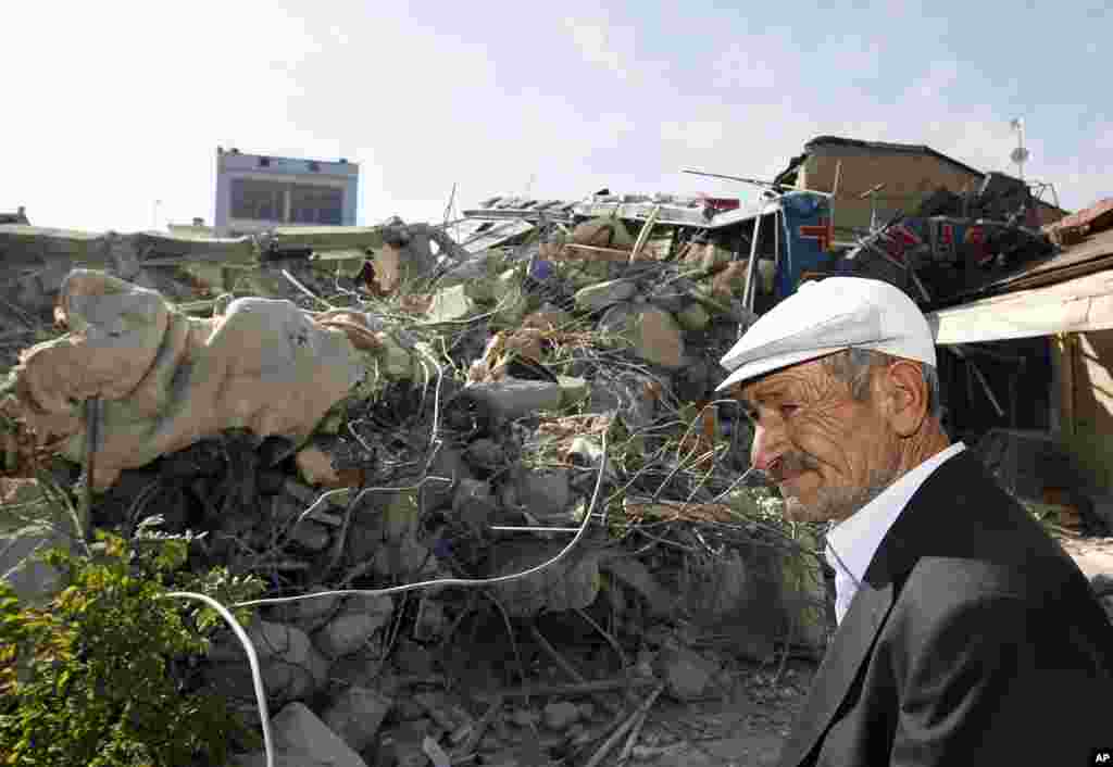 A man stands by debris of his collapsed house in Ercis, Van, eastern Turkey, October 24, 2011. (AP)