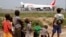 FILE - A humanitarian plane of the World Food Program (WFP) unloads sacks of cereal at Mpoko international airport in Bangui, which is located near a camp for displaced people.