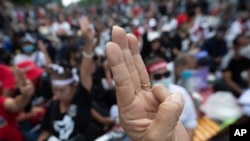 Pro-democracy demonstrators raise a three-finger salute, a symbol of resistance, outside parliament in Bangkok, Thailand, Sept. 24, 2020. Lawmakers were expected to vote Thursday on six proposed constitutional amendments.