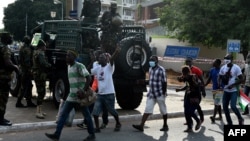 Les partisans du Congrès national démocratique (NDC) de l'opposition chantent, dansent et font des gestes sur la route principale de la Commission électorale, à Accra, au Ghana, le 8 décembre 2020.