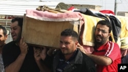 Residents carry a coffin during a funeral for a bomb attack victim in Baghdad's Ur district October 28, 2011.