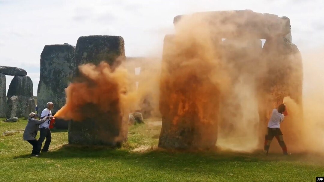 Una imagen tomada de un vídeo publicado por el grupo Just Stop Oil muestra a activistas rociando una sustancia naranja en Stonehenge en Wiltshire, suroeste de Inglaterra, el 19 de junio de 2024.