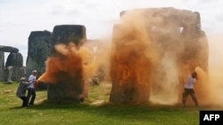 Una imagen tomada de un vídeo publicado por el grupo Just Stop Oil muestra a activistas rociando una sustancia naranja en Stonehenge en Wiltshire, suroeste de Inglaterra, el 19 de junio de 2024.