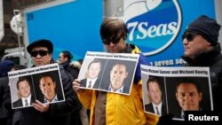 Orang-orang memegang plakat yang menyerukan China untuk membebaskan tahanan Kanada Michael Spavor dan Michael Kovrig di luar sidang pengadilan. (Foto: Reuters/Lindsey Wasson)