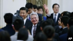 German President Joachim Gauck waves next to Chinese President Xi Jinping as they attend the opening ceremony of the Sino-German Youth Friendly Exchange Year at the Great Hall of the People in Beijing, March 21, 2016.