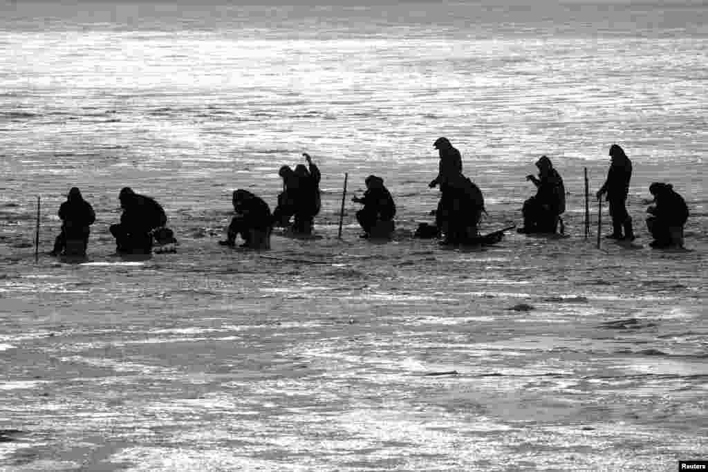 People fish on the frozen Dnipro River in Kyiv, Ukraine, Feb. 15, 2021.