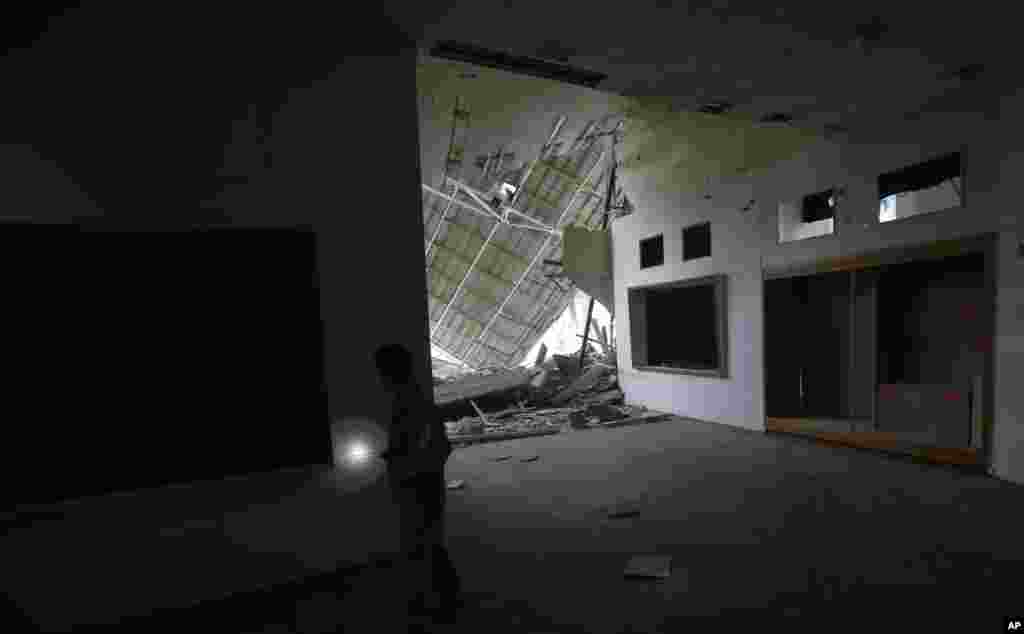 A volunteer inspects a damaged museum that was shelled in late August, in the city of Donetsk, eastern Ukraine, Sept. 22, 2014. 