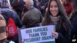 Un grupo de profesores de leyes aprueban la acción ejecutiva del presidente Barack Obama sobre inmigración, al igual que esta inmigrante que se la agradece con un letrero.