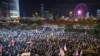 FILE - Protesters hold up their lit-up mobile phones as they attend a gathering at the Edinburgh place in Hong Kong, China, Nov. 28, 2019.