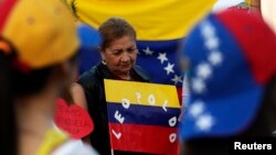 Una ciudadana venezolana residente en México sostiene un rótulo con el nombre de López.