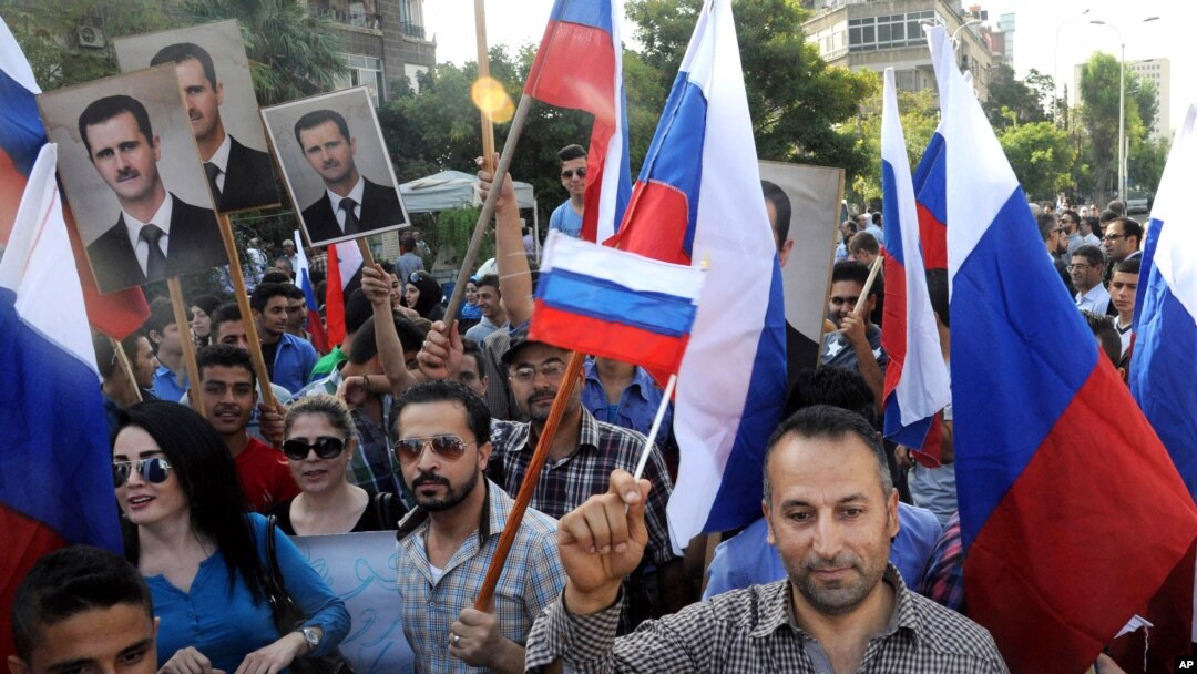 This photo from the Syrian official news agency SANA shows Syrians rallying in front of the Russian Embassy in Damascus to show their thanks to Russia for its intervention in Syria, Oct. 13, 2015. But few Syrians who leave their country are finding Russia welcoming. 