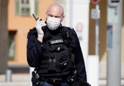 A police officer wearing a face mask patrols the Promenade des Anglais in Nice, as Nice's mayor said Friday he will be closing a part of it as part of measures to fight the coronavirus (COVID-19) outbreak spread in France, March 20, 2020.