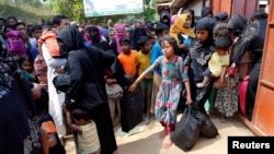 FILE - Rohingya refugees collect aid supplies including food and medicine, sent from Malaysia, at Kutupalang Unregistered Refugee Camp in Cox’s Bazar, Bangladesh, Feb. 15, 2017.