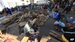 A Zimbabwean vendor ponders his next move after he had his wares removed by police from the streets of Harare, Wednesday, July, 8, 2015. Minor scuffles ensued as police officers drove out thousands of vendors selling their wares on the sidewalks and pavements of Harare. (AP Photo/Tsvangirayi Mukwazhi)