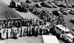 FILE - The line of people awaiting polio shots at Evansville (Ind.) Municipal Stadium was still long, four hours after the clinic started, when this picture was taken, Aug. 9, 1959. During the eight-hour program, about 14,000 people received shots.