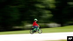 A child rides a bicycle in a park which reopened after several weeks of closure, in Milan, Italy, May 4, 2020.