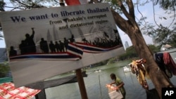 Seorang demonstran anti-pemerintah membawa kotak berisi barang-barang miliknya di Taman  Lumpini, Bangkok (7/3).