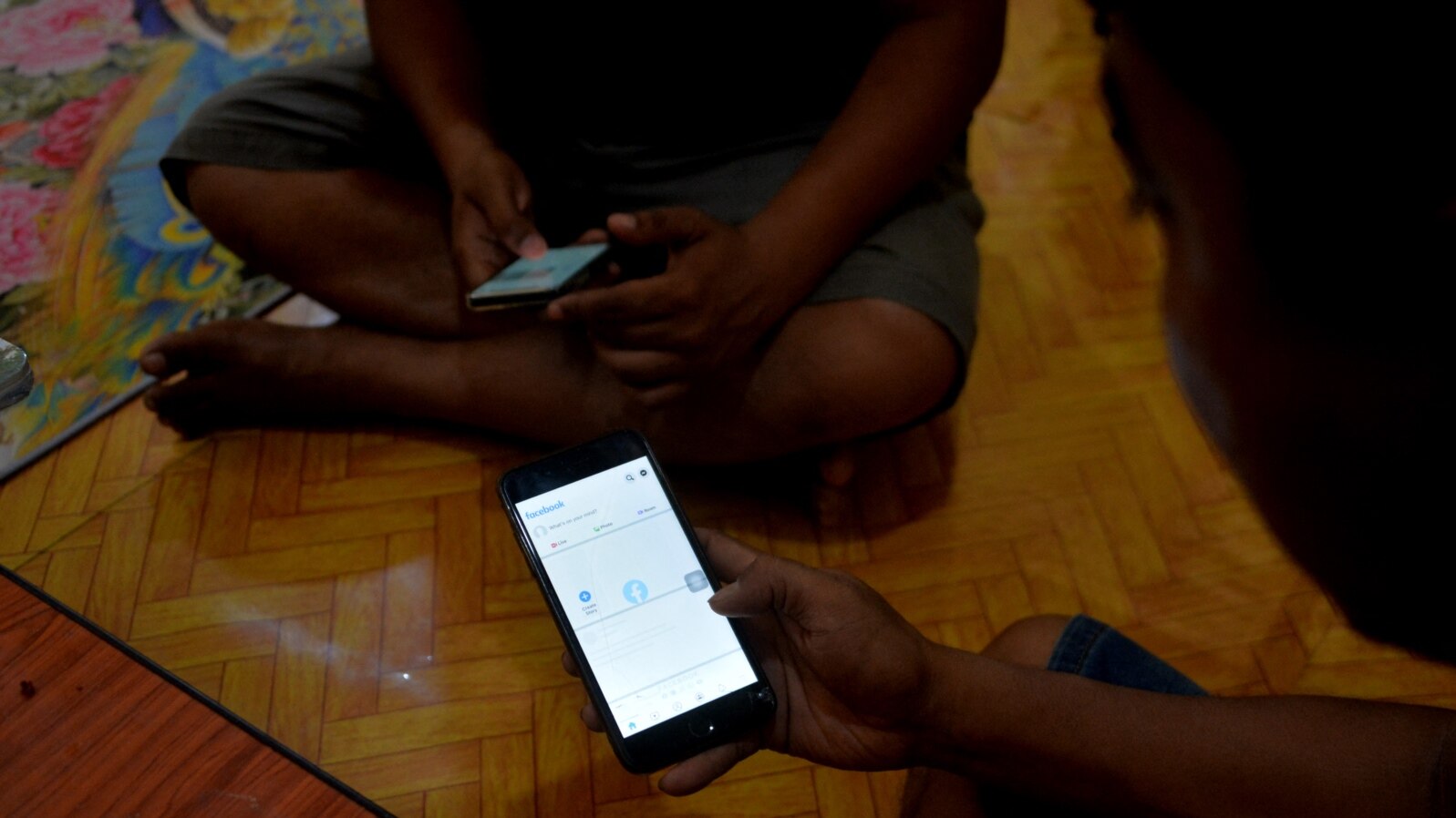 FILE - Young men use their mobile phones in Naypyidaw on March 16, 2021, as Myanmar military authorities ordered telecommunication companies to restrict services on their mobile data networks.