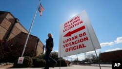 A sign points potential voters to an official polling location during early voting in Dallas, Feb. 26, 2020.