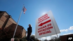 A sign points potential voters to an official polling location during early voting in Dallas, Feb. 26, 2020.
