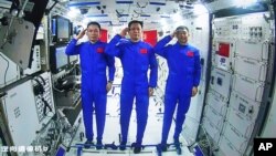 Tiga astronaut China, dari kiri: Tang Hongbo, Nie Haisheng, dan Liu Boming memberikan hormat kepada Presiden China Xi Jinping saat melakukan telekonferensi dari stasiun antariksa (foto: dok). 