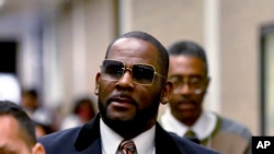 R Kelly, tengah, berjalan meninggalkan Daley Center, Chicago, setelah persidangan atas kasus yang membelitnya pada 8 Mei 2019. (Foto: AP/Matt Marton)